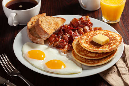 traditional full american breakfast eggs pancakes with bacon and toastの写真素材