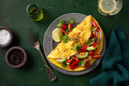 omelette with tomato, avocado onion chili and sweet corn. healthy keto diet low carb breakfastの写真素材