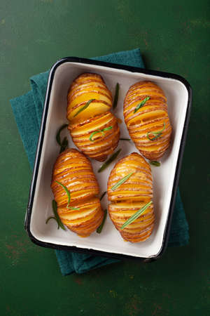 baked hasselback potato with cheddar cheese and rosemaryの写真素材