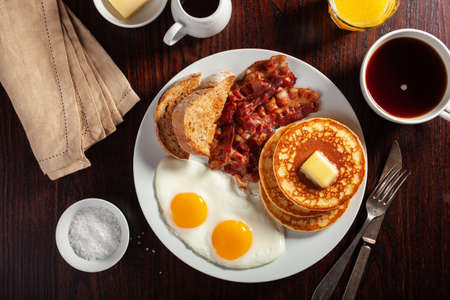 traditional full american breakfast eggs pancakes with bacon and toastの写真素材