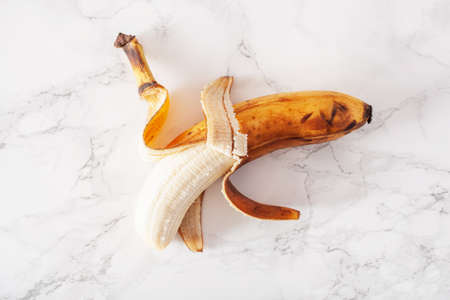 ripe overripe organic banana on marble background. ugly food zero waste conceptの写真素材