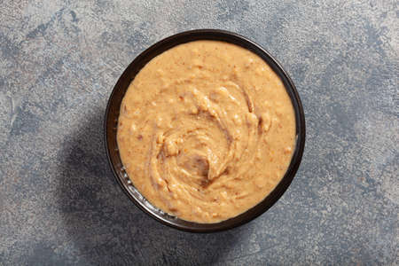smooth peanut butter in bowl on gray backgroundの写真素材