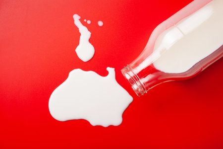 bad milk lactose intolerance allergy. milk bottle splatter. avoid dangerous dairyの写真素材
