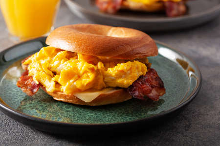 breakfast egg and bacon sandwich on bagel with cheeseの写真素材