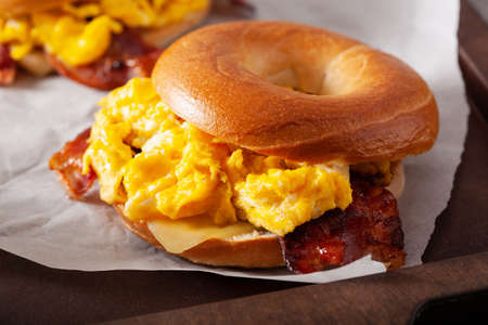 breakfast egg and bacon sandwich on bagel with cheeseの写真素材
