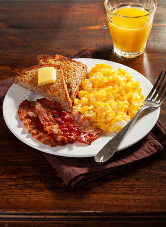 traditional scrambled egg breakfast with bacon and toastの写真素材