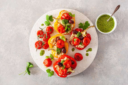 stuffed bell peppers with quinoa tomatoes olives and herb sauce chimichurriの写真素材