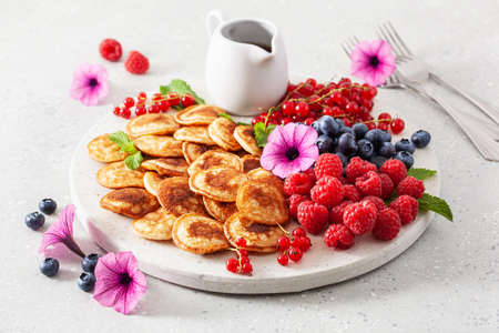 american mini pancake board with berries and maple syrupの写真素材