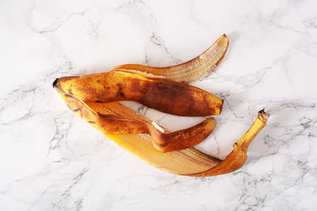 ripe overripe organic banana peel on marble background. ugly food zero waste conceptの写真素材