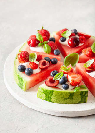 watermelon pizza slices with yogurt and berries, summer dessertの写真素材