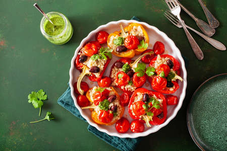 stuffed bell peppers with quinoa tomatoes olives and herb sauce chimichurriの写真素材