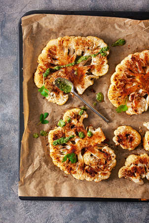 cauliflower steaks with herb and spice on baking tray. plant based meat substituteの写真素材