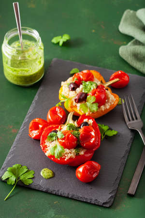 stuffed bell peppers with quinoa tomatoes olives and herb sauce chimichurriの写真素材