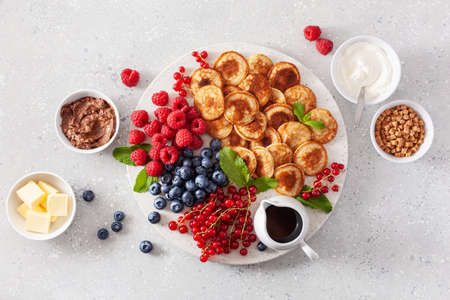 american mini pancake board with berries and maple syrupの写真素材