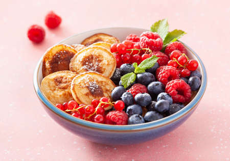 mini pancake breakfast bowl with berries and maple syrupの写真素材
