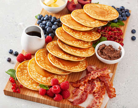 american pancake board with bacon berries maple syrup butterの写真素材