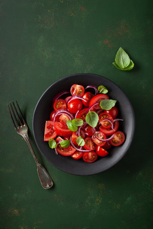 healthy tomato salad with onion basil olive oil and balsamic vinegarの写真素材