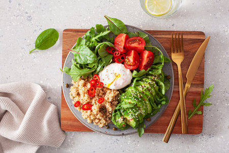 quinoa with poached egg, avocado tomato salad leaves. healthy vegetarian lunch breakfastの写真素材