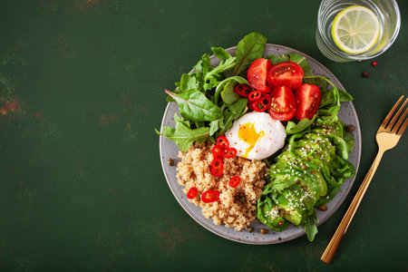 quinoa with poached egg, avocado tomato salad leaves. healthy vegetarian lunch breakfastの写真素材