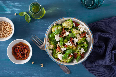 healthy broccoli salad with feta cheese sun dried tomatoes pine nuts. vegetarian low carb keto dietの写真素材