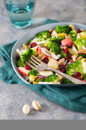 healthy broccoli salad with apple onion dried cranberries pistachio. vegan low carb dietの写真素材