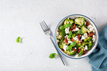 healthy broccoli salad with feta cheese sun dried tomatoes pine nuts. vegetarian low carb keto dietの写真素材