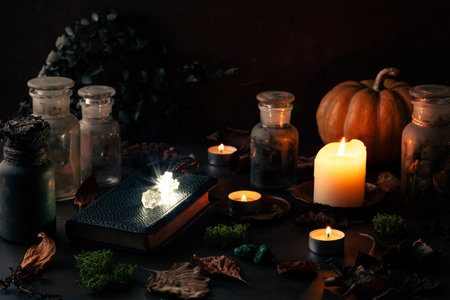 Witchcraft still life concept with potions, spell book, herbs ingredients candles and magical equipmentの写真素材