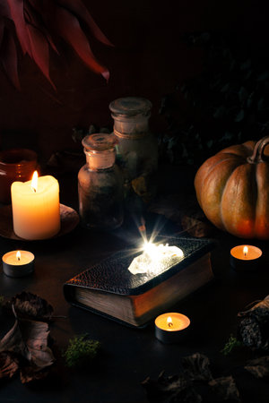 Witchcraft still life concept with potions, spell book, herbs ingredients candles and magical equipmentの写真素材