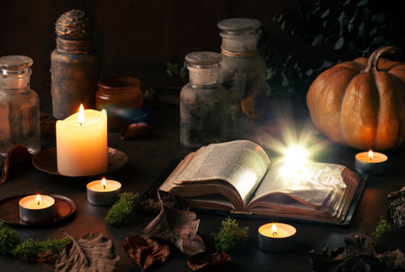 Witchcraft still life concept with potions, spell book, herbs ingredients candles and magical equipmentの写真素材