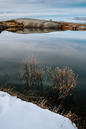 dark moody northern landscape, small lake on a top of mountain Rogne in Norwayの写真素材