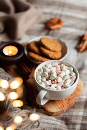 warm cozy bedroom interior with cup of hot chocolate on tray, candles christmas lightsの写真素材