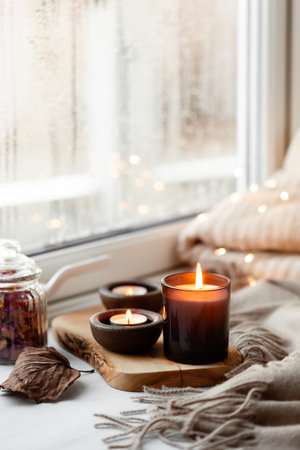 warm cozy window arrangement, winter or autumn concept, candles throw lightsの写真素材