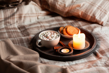 warm cozy bedroom interior with cup of hot chocolate on tray, candlesの写真素材