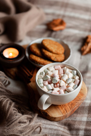 warm cozy bedroom winter or autumn concept, cup of hot chocolate on tray, candles throwの写真素材