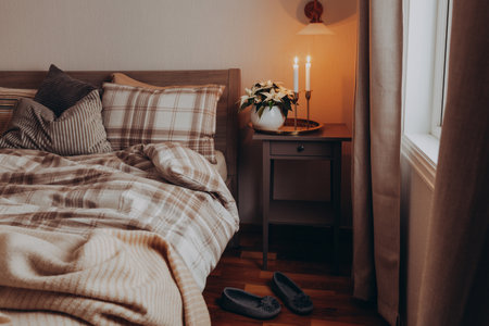 cozy scandinavian bedroom interior in natural tones, blanket candles houseplantsの写真素材