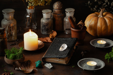 Witchcraft still life concept with potion, spell book, herbs ingredients candles and magical equipmentの写真素材