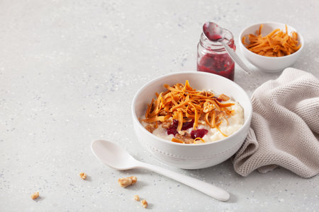 rice pudding with Norwegian brunost traditional brown cheese and raspberry jamの写真素材