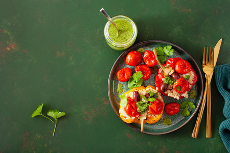 stuffed bell peppers with quinoa tomatoes olives and herb sauce chimichurriの写真素材