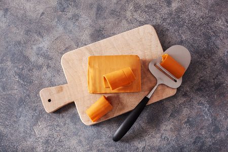 Norwegian brunost traditional brown cheese block and slicerの写真素材