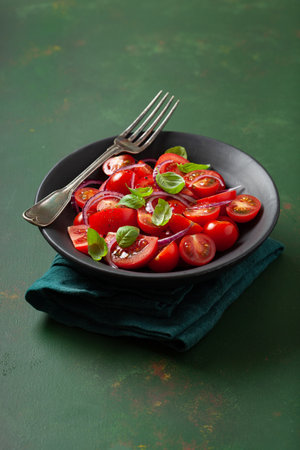 healthy tomato salad with onion basil olive oil and balsamic vinegarの写真素材