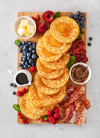 american pancake board with bacon berries maple syrup butterの写真素材