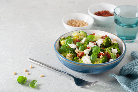 healthy broccoli salad with feta cheese sun dried tomatoes pine nuts. vegetarian low carb keto dietの写真素材