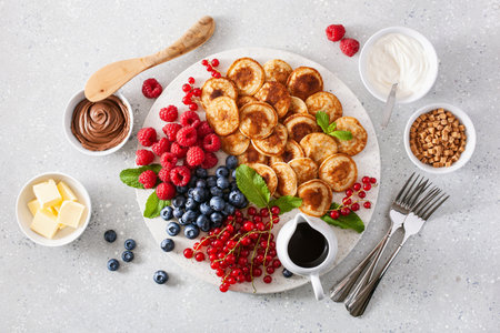 american mini pancake board with berries and maple syrupの写真素材