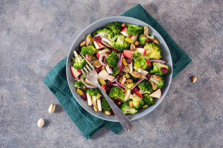 healthy broccoli salad with apple onion dried cranberries pistachio. vegan low carb dietの写真素材