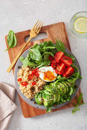 quinoa with poached egg, avocado tomato salad leaves. healthy vegetarian lunch breakfastの写真素材