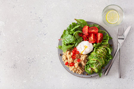 quinoa with poached egg, avocado tomato salad leaves. healthy vegetarian lunch breakfastの写真素材