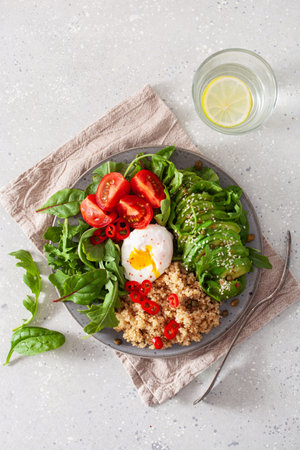quinoa with poached egg, avocado tomato salad leaves. healthy vegetarian lunch breakfastの写真素材