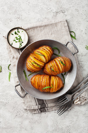 baked hasselback potato with cheddar cheese and rosemaryの写真素材