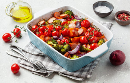 oven baked vegetables and sausages, healthy lunch, sweet potato onion tomato broccoliの写真素材