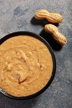 smooth peanut butter in bowl on gray backgroundの写真素材